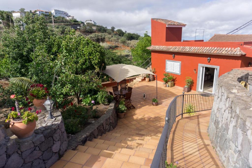 贝加德圣马特奥La Casa Del Campo的房屋设有带桌子和遮阳伞的庭院