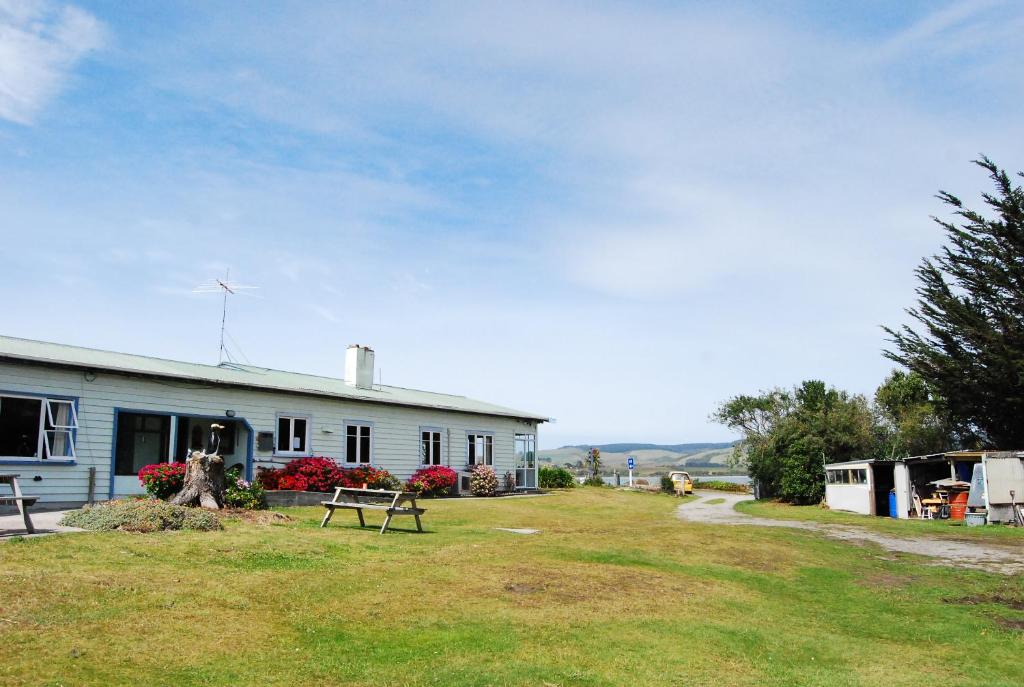 OwakaSurat Bay Lodge by the Sea/Backpackers Hostel的前面有一张野餐桌的房子