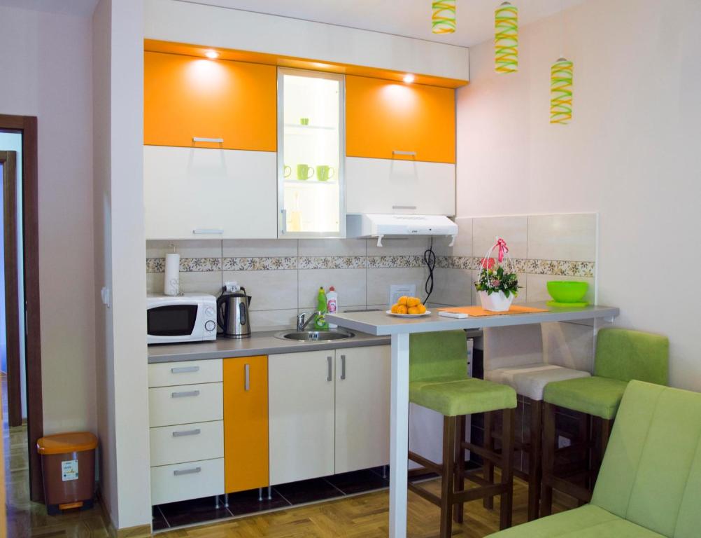 弗尔尼亚奇卡矿泉镇莉娜公寓的一间拥有白色橱柜和绿色装饰的厨房