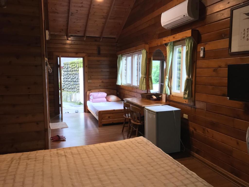 鹿谷乡金族木屋的一间卧室配有一张床和一张书桌