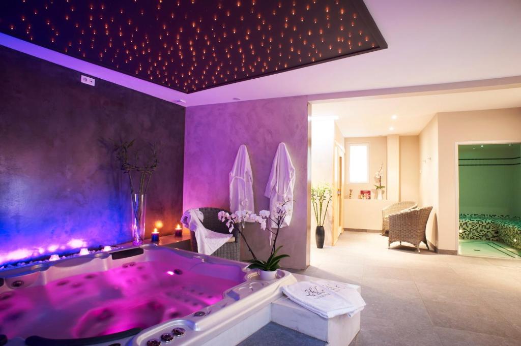 拉波勒鲁特蒂亚Spa酒店的一间客房内配有粉红色浴缸的浴室