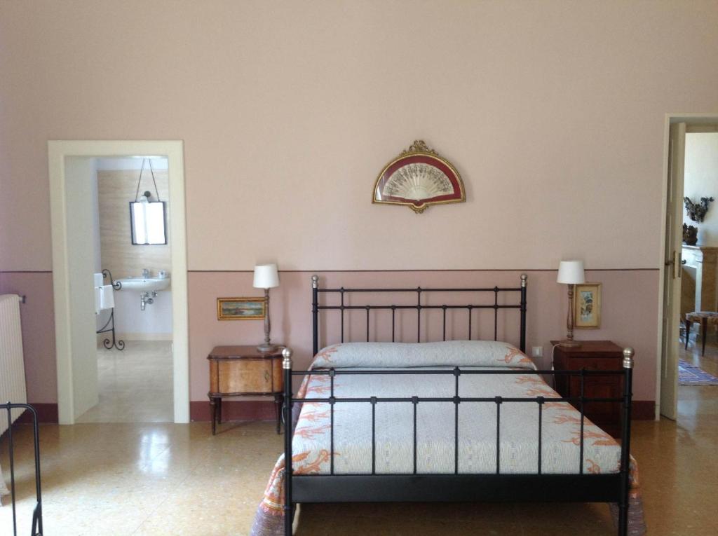 洛雷托·阿普鲁蒂诺劳瑞图旅馆的卧室配有一张床,墙上设有镜子