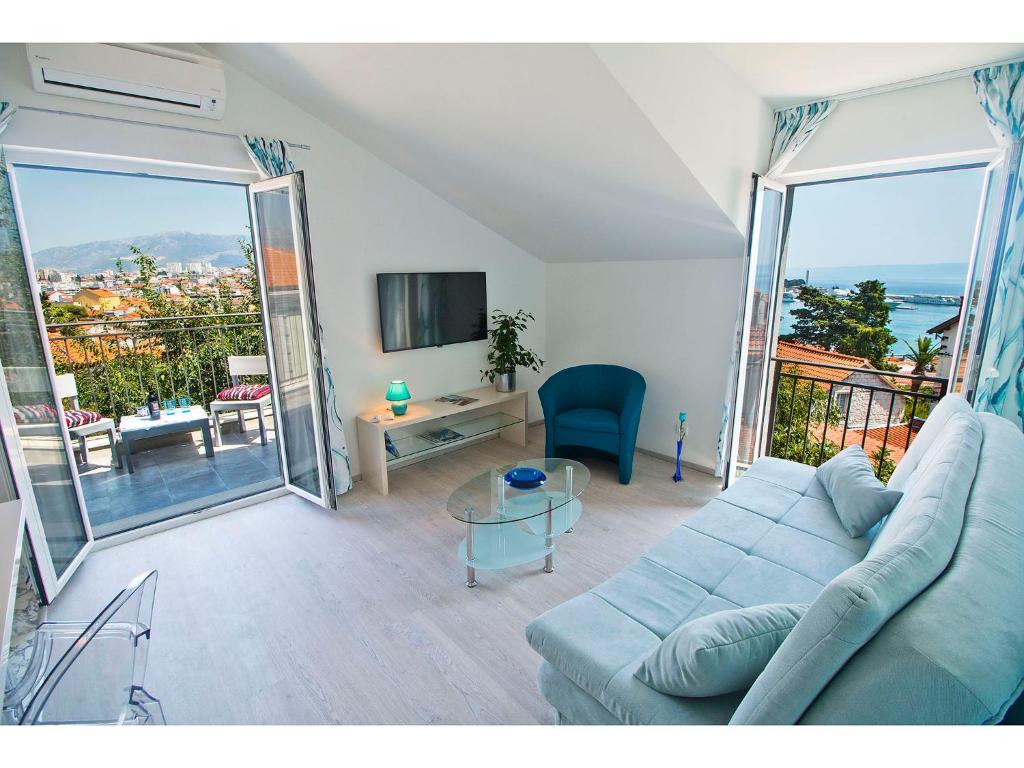 斯普利特豪华马里安公寓的一间带蓝色沙发的客厅和一个阳台