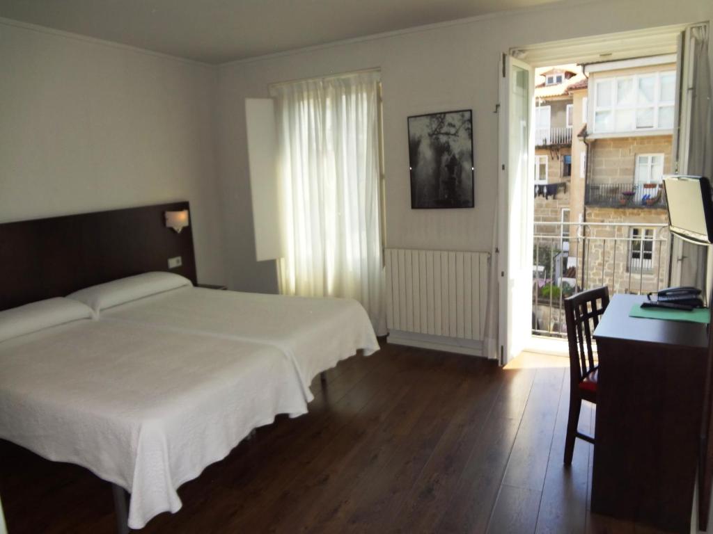 奥伦塞易瑞克斯酒店的一间卧室配有一张床、一张书桌和一个窗户。