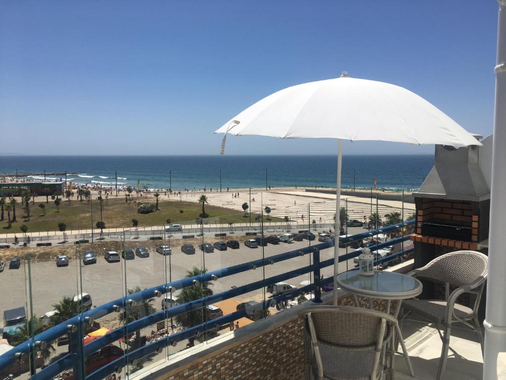 卡帕里卡海岸卡帕里卡海岸公寓的阳台配有遮阳伞,享有海滩美景