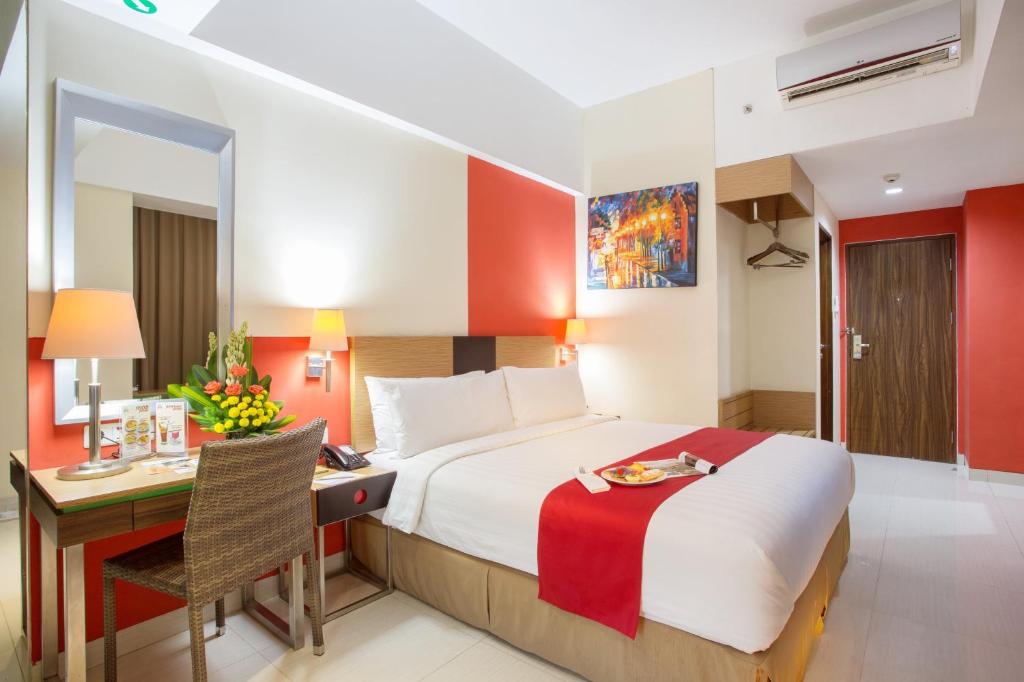 日惹日惹安巴路莫中庭尊贵酒店的酒店客房设有一张大床和一张书桌。
