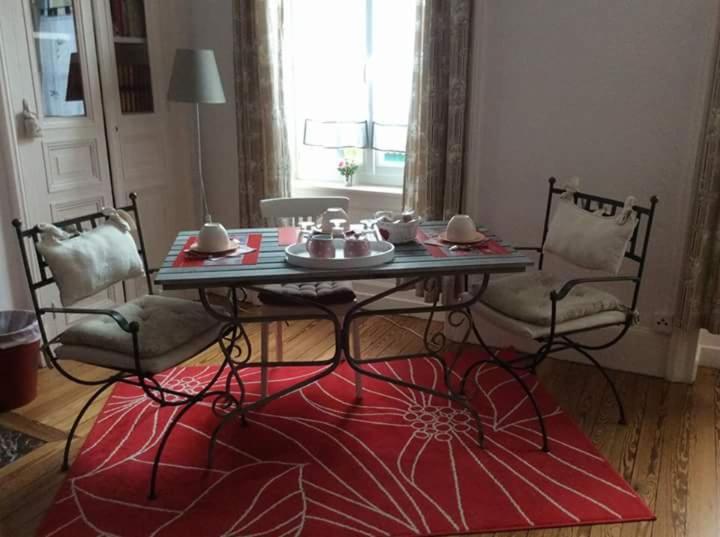 Saint-Pierre-Églisela Tourelle en Normandie的红色地毯的房间里一张桌子和椅子