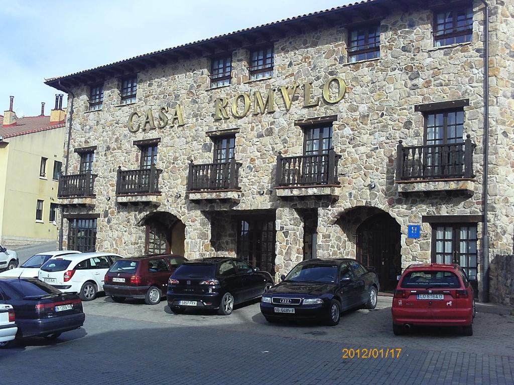 杜鲁埃洛德拉谢拉卡萨罗慕洛酒店的一座石头建筑,前面停有汽车