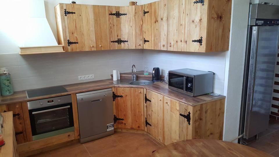 派德Järva Jahindusklubi HOSTEL的厨房配有木制橱柜、水槽和微波炉