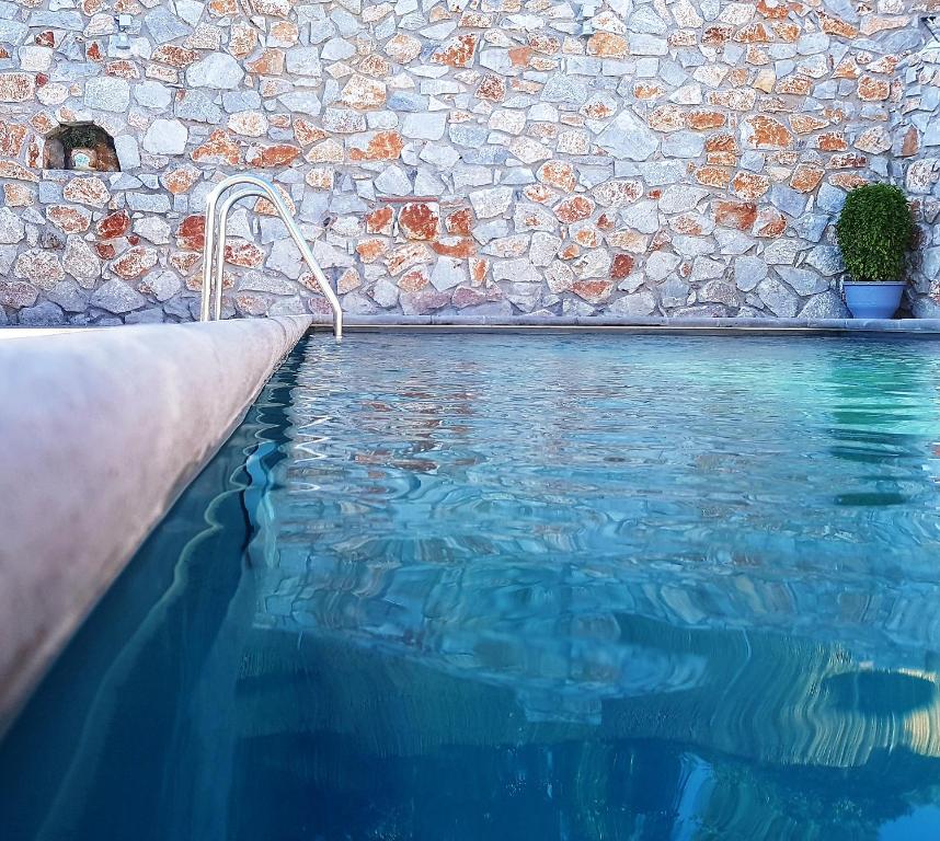 罗达奇诺Maistrali的石头墙前的游泳池