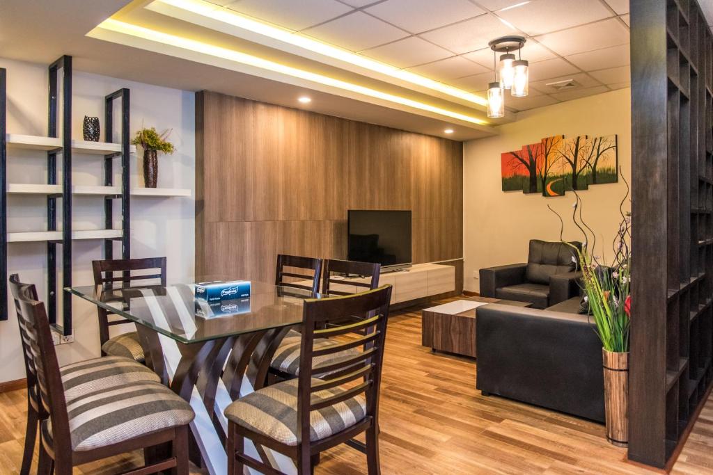 迦瓦拉科尔Classic Serviced Apartments的一间带桌椅和沙发的用餐室