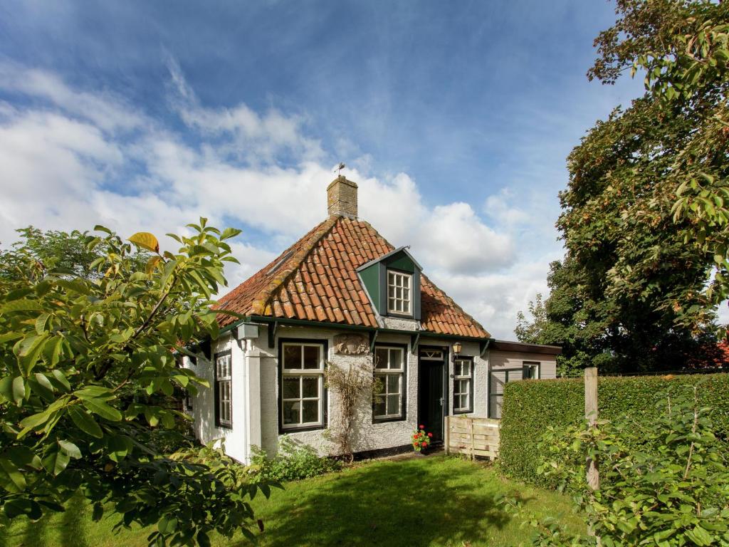 内斯Fairytale Cottage in Nes Friesland with garden的一间白色的小房子,有红色的屋顶