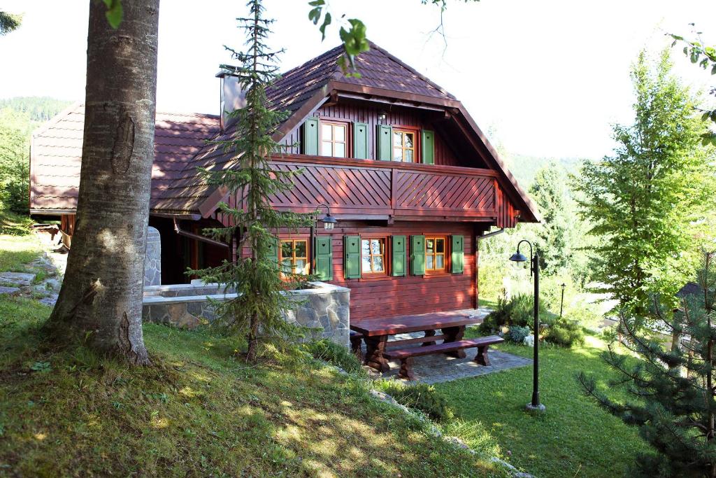 Padeški VrhNatural Wooden Sweetheart的前面设有长凳的小木房子
