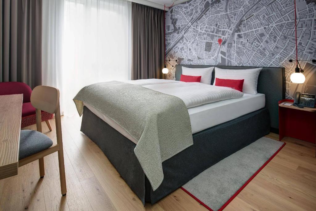 杜伊斯堡杜伊斯堡城际酒店的一间卧室配有一张带红色枕头的大床