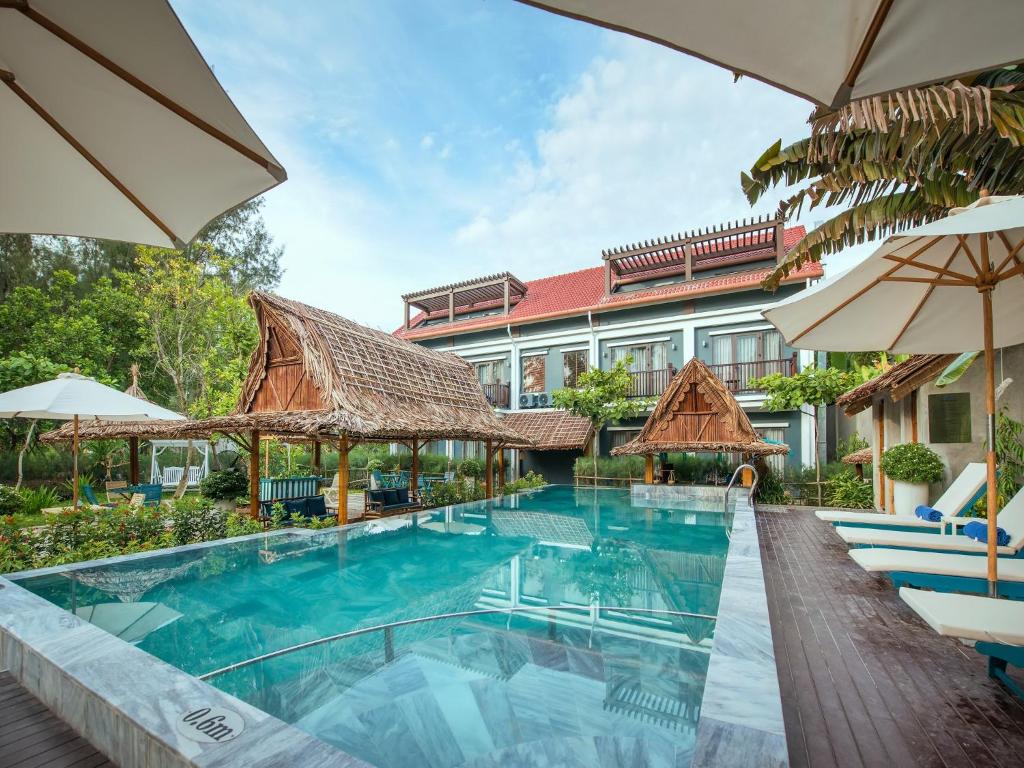 会安AIRA Boutique Hoi An Hotel & Villa的一座带游泳池和大楼的度假村