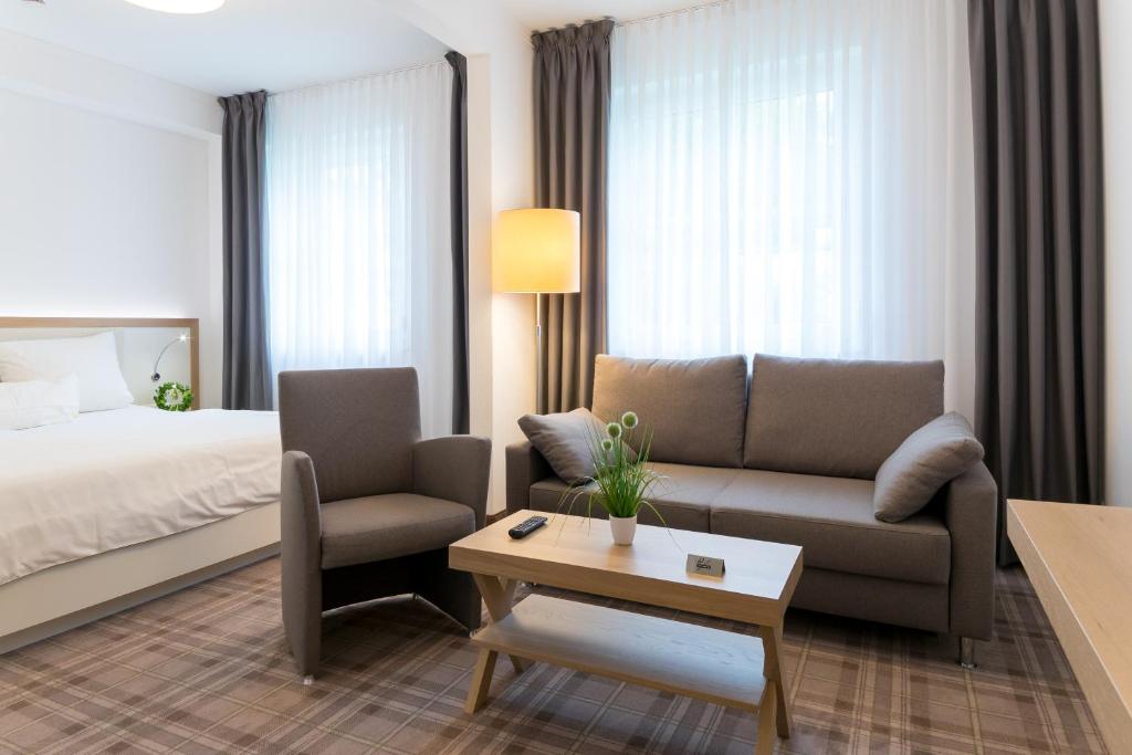 不莱梅库泽腾酒店的酒店客房配有床、沙发和桌子。