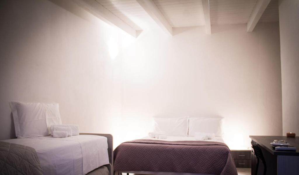 卡斯泰拉内塔Masseria D'Aprile的小房间设有两张床和一张桌子
