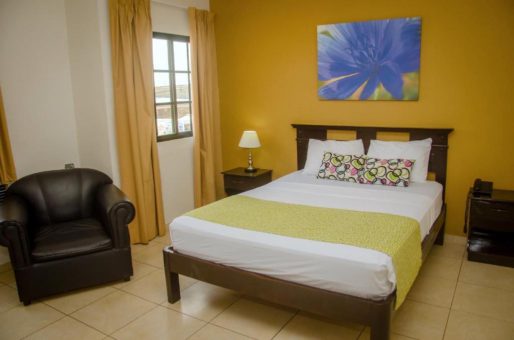 戴维塞万提斯酒店的一间卧室配有一张大床和一把椅子