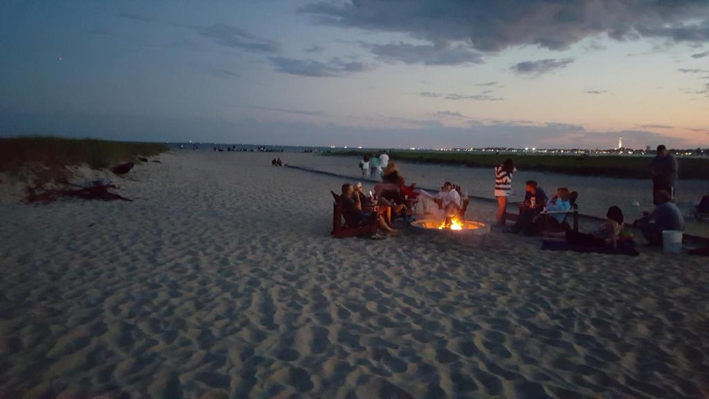 北特鲁罗蓝海汽车旅馆的一群人坐在海滩上的 ⁇ 火旁