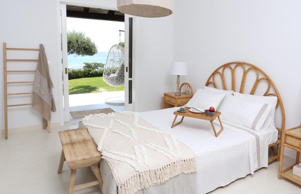 格利法达Seafront Calista Beach House With Garden的白色卧室配有床和桌子