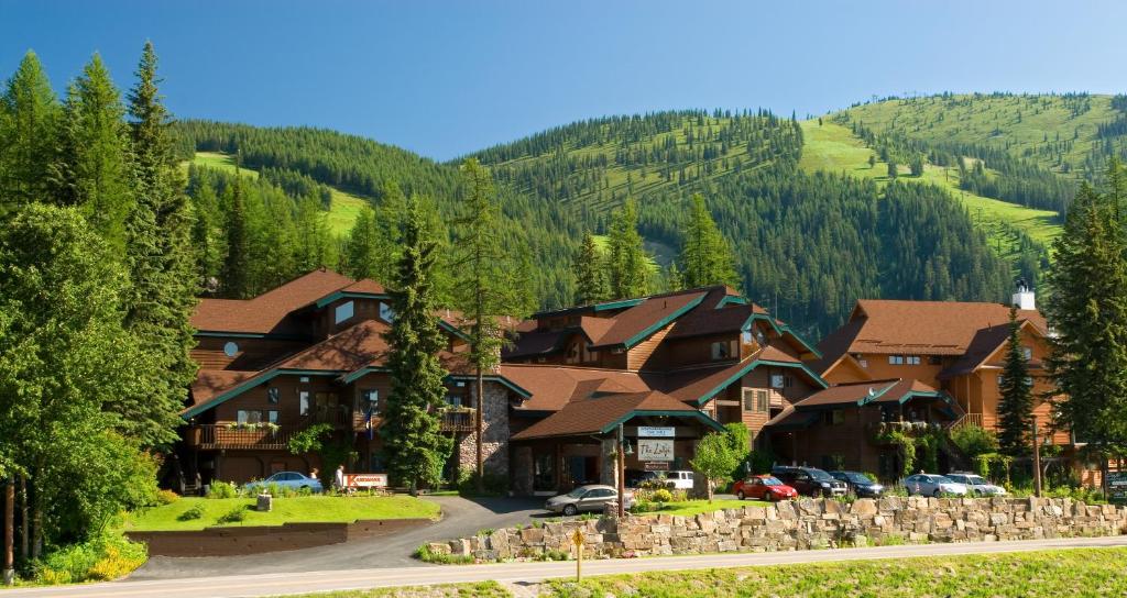 白鱼镇Kandahar Lodge at Whitefish Mountain Resort的山村里的一个村庄,有汽车停放