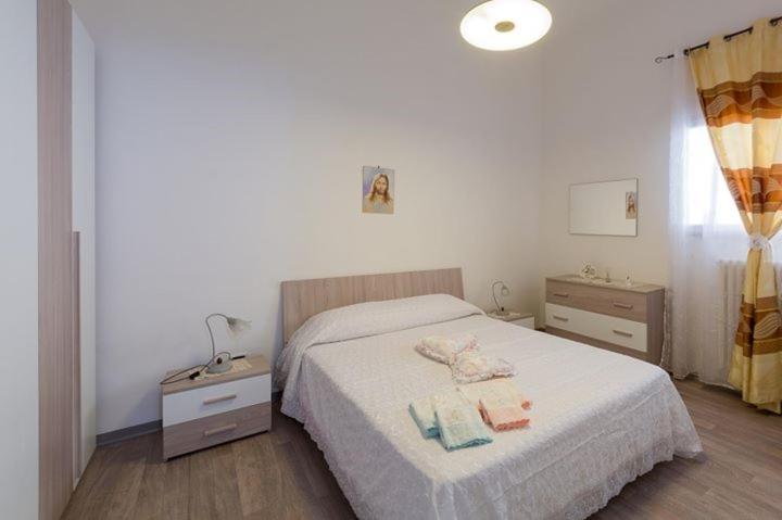 安德里亚Casa vacanza Simone的一间卧室配有一张床和两个床头柜,配有毛巾