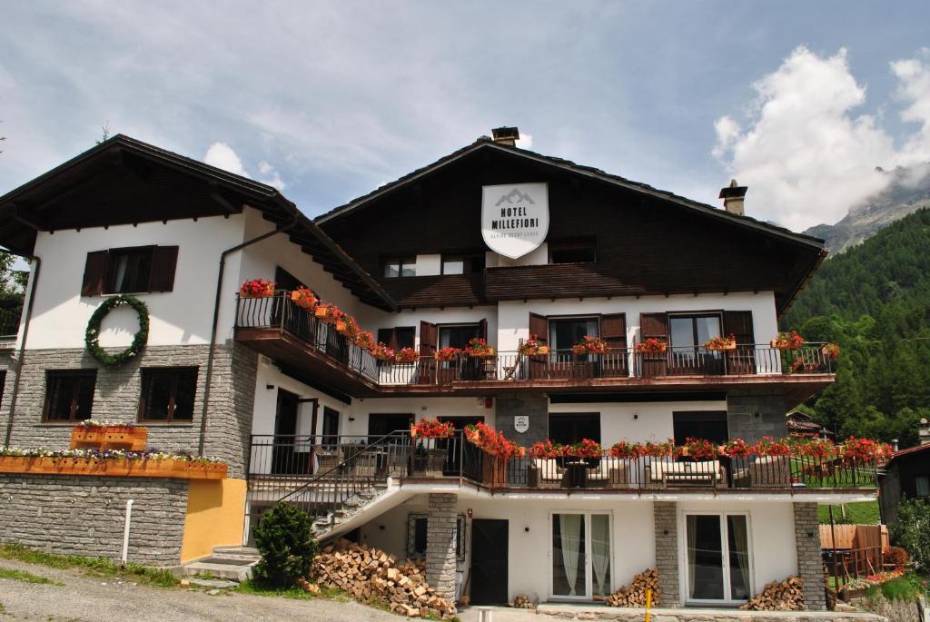 瓦托内切Hotell Millefiori- Alpine Event Lodge的一座在阳台上种满鲜花的建筑