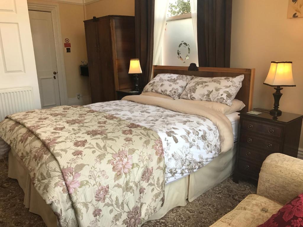 布里德灵顿赫里斯旅馆的一间卧室配有床、梳妆台和灯