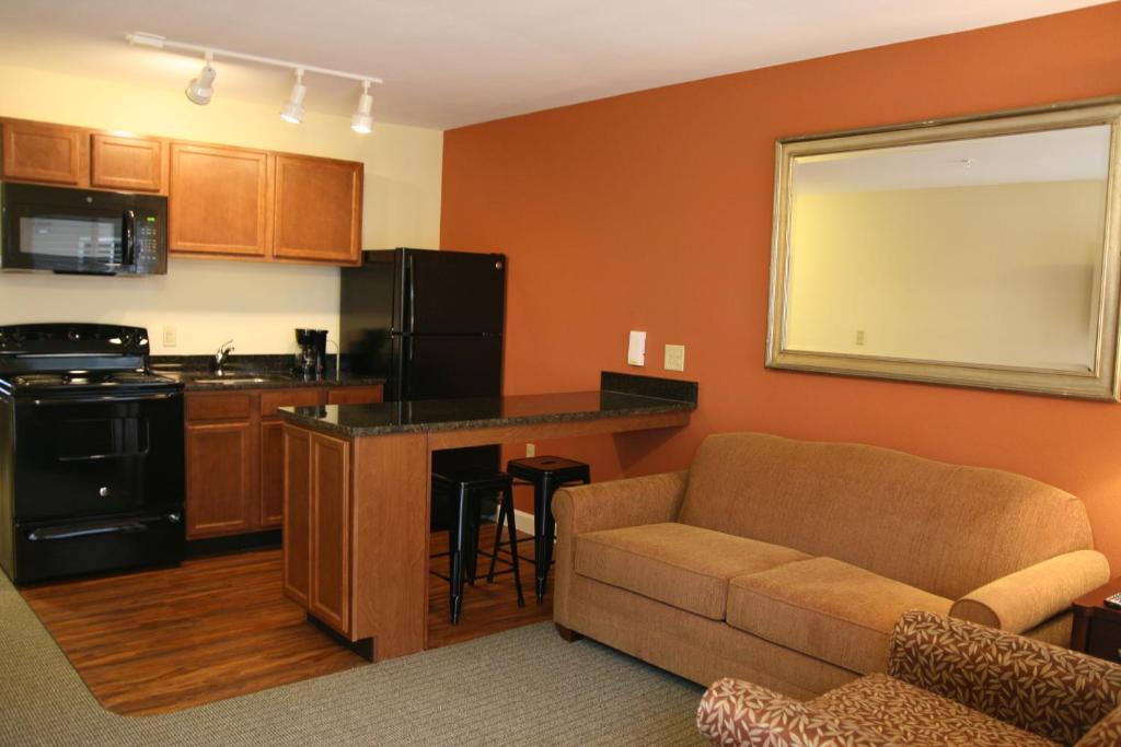 穆尔斯维尔Affordable Suites Mooresville的带沙发的客厅和厨房