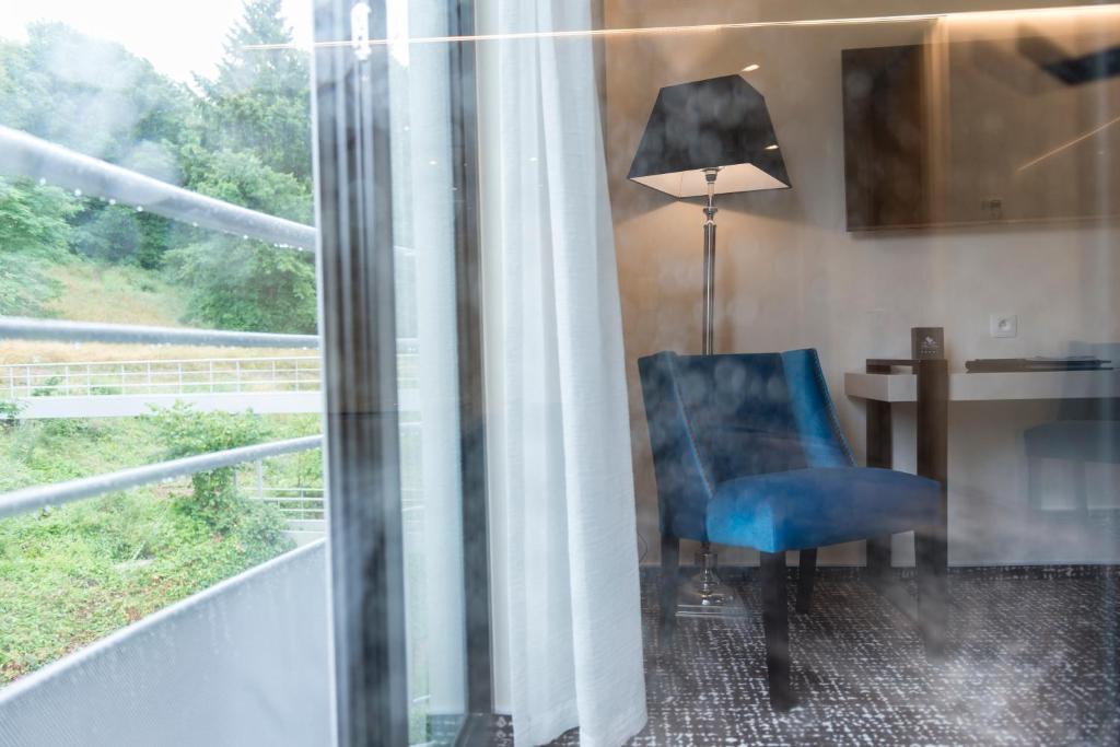 绍德方丹莱沙托德特梅斯酒店的靠窗边桌子前的蓝色椅子
