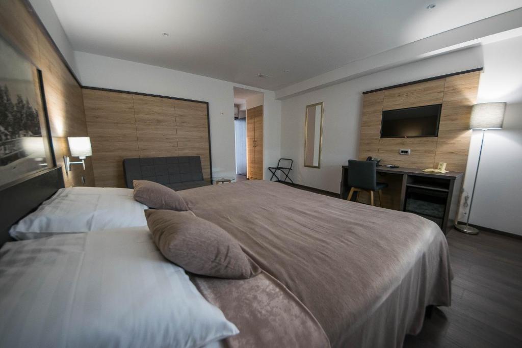 库蒂纳国王酒吧旅馆的一间卧室配有一张带枕头的大床和一张书桌