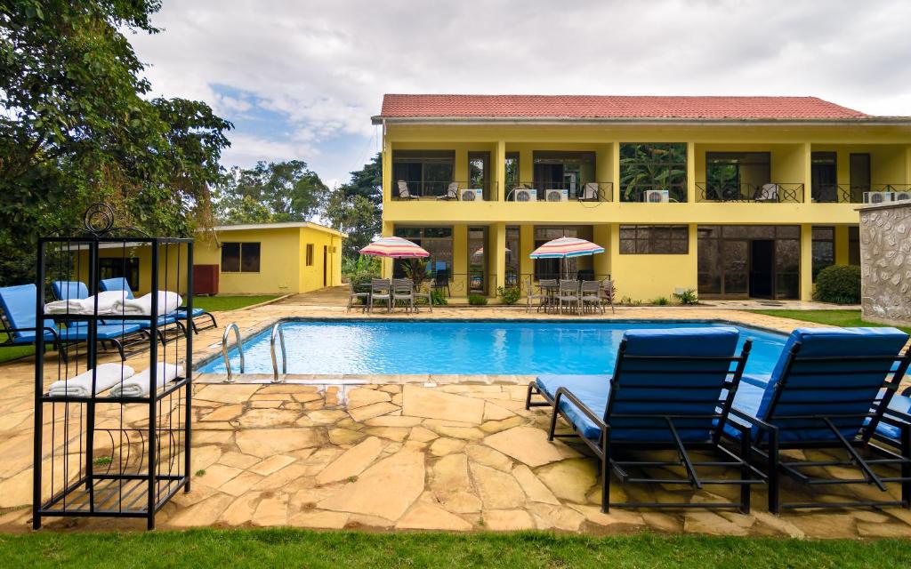 阿鲁沙姆里阿鲁沙酒店的一座带蓝色椅子的游泳池的房子