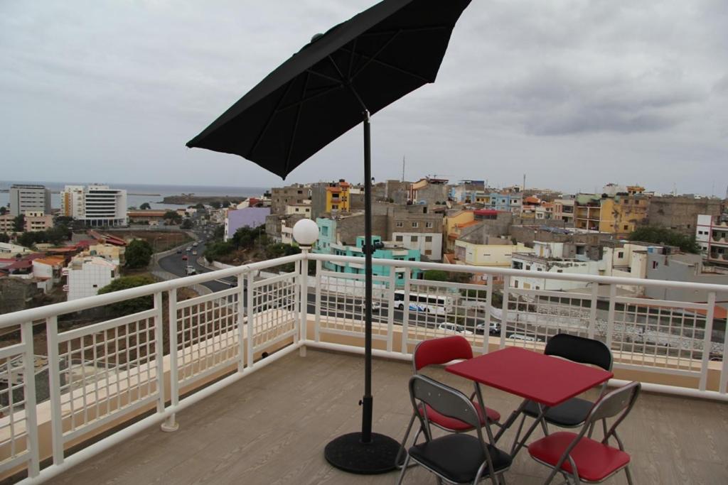 普拉亚Apartamento António的阳台配有桌椅和遮阳伞