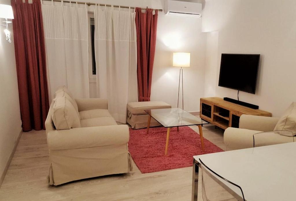 卡斯卡伊斯Suites Apartments的客厅配有白色家具和平面电视
