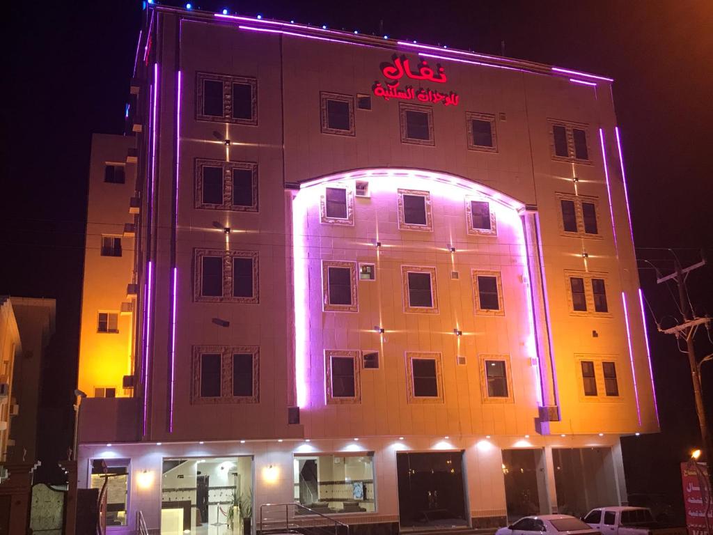 比沙堡Nafal Hotel Suites的建筑的侧面有紫色的灯