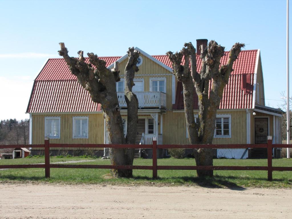 FågelmaraStålemara Gård Krickan的两棵树在一座带围栏的房子前面