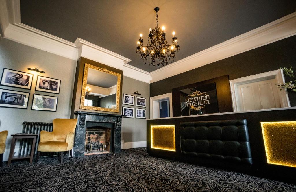 阿宾登史蒂文顿豪斯酒店的客厅设有壁炉和镜子