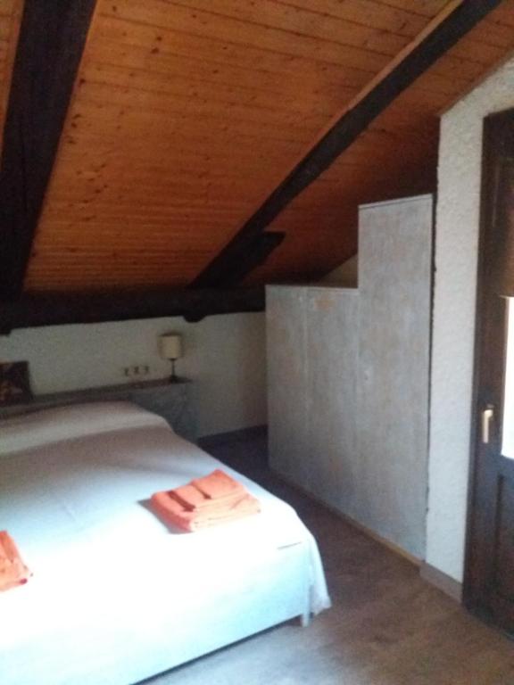 科姆梅扎杜拉马索德尔卡皮特尔公寓的卧室配有白色床和木制天花板