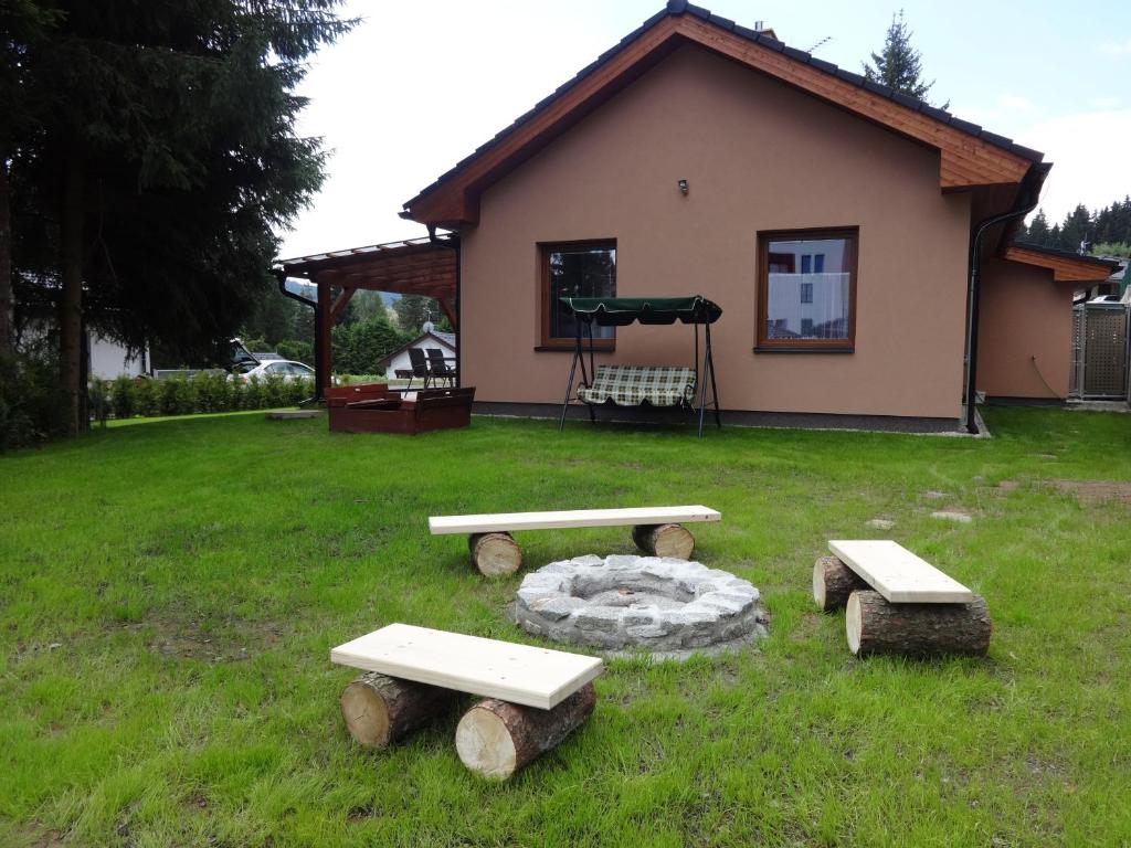 伏尔塔瓦河畔利普诺Moderni Domek Lipno的一群野餐桌在房子前面的草上