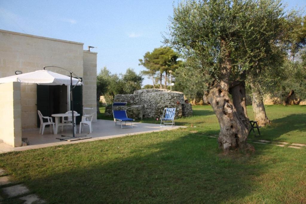 新福卡Casa Vacanze Mare e Ulivi的一个带桌椅和一棵树的院子