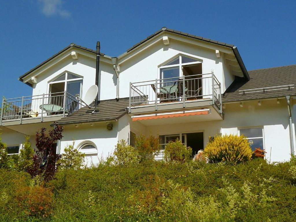 维林根2 separate flats with balcony on the ski slope的白色的房子,上面设有阳台