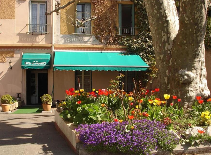 迪涅莱班Hotel De Provence的一座花园,在一座有树的建筑前