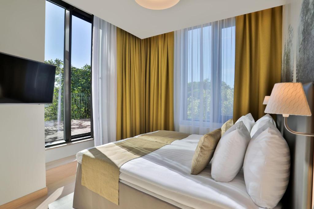 塔林塔林百年纪念酒店的酒店客房设有一张带大窗户的床。