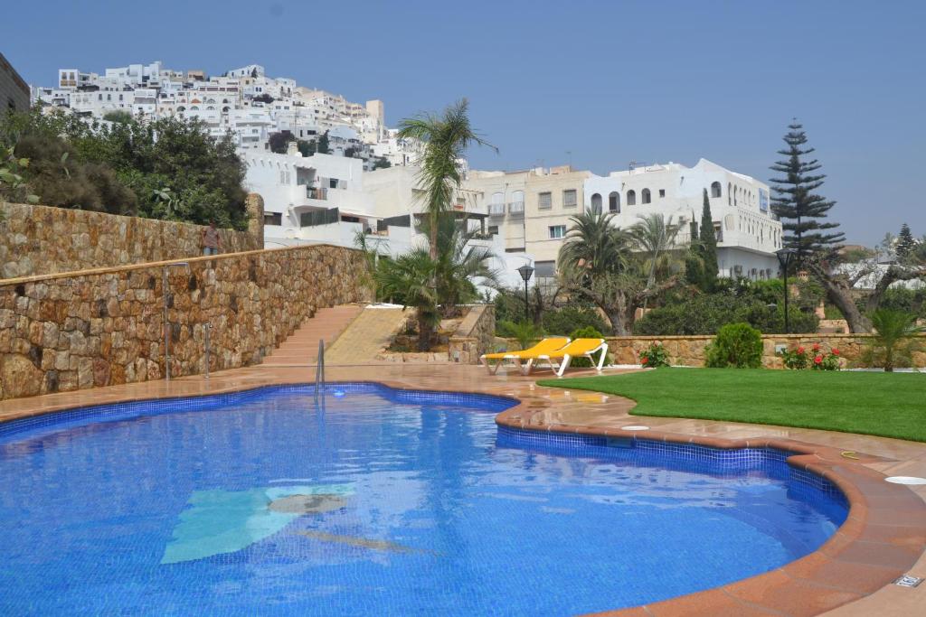 莫哈卡尔Hotel Simón的一个大型蓝色游泳池,其建筑背景为:
