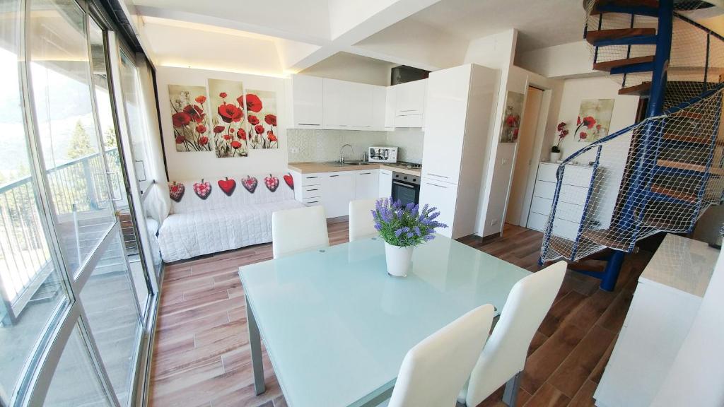 马里尔伊瓦Apartment Ski Marilleva 1400的厨房以及带白色桌椅的起居室。