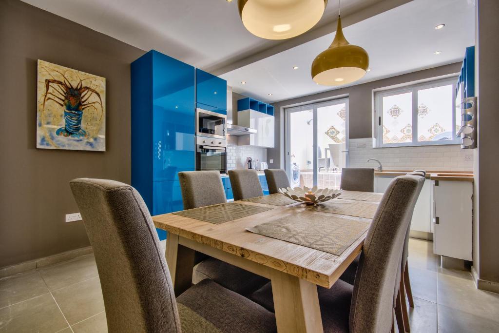 斯利马Amazing 4-bedroom Sliema Town House with Jacuzzi的厨房以及带木桌和椅子的用餐室。