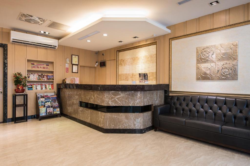 高雄南海商务大饭店的一间设有皮革长椅和酒吧的等候室