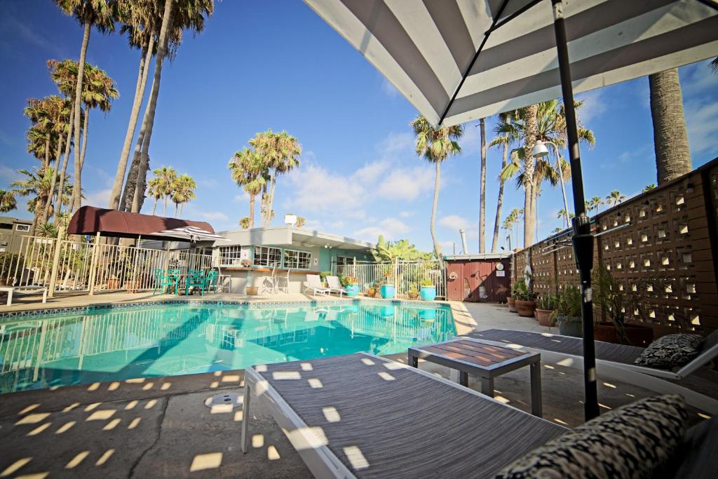 圣地亚哥海洋别墅旅馆的一座拥有棕榈树和遮阳伞的游泳池