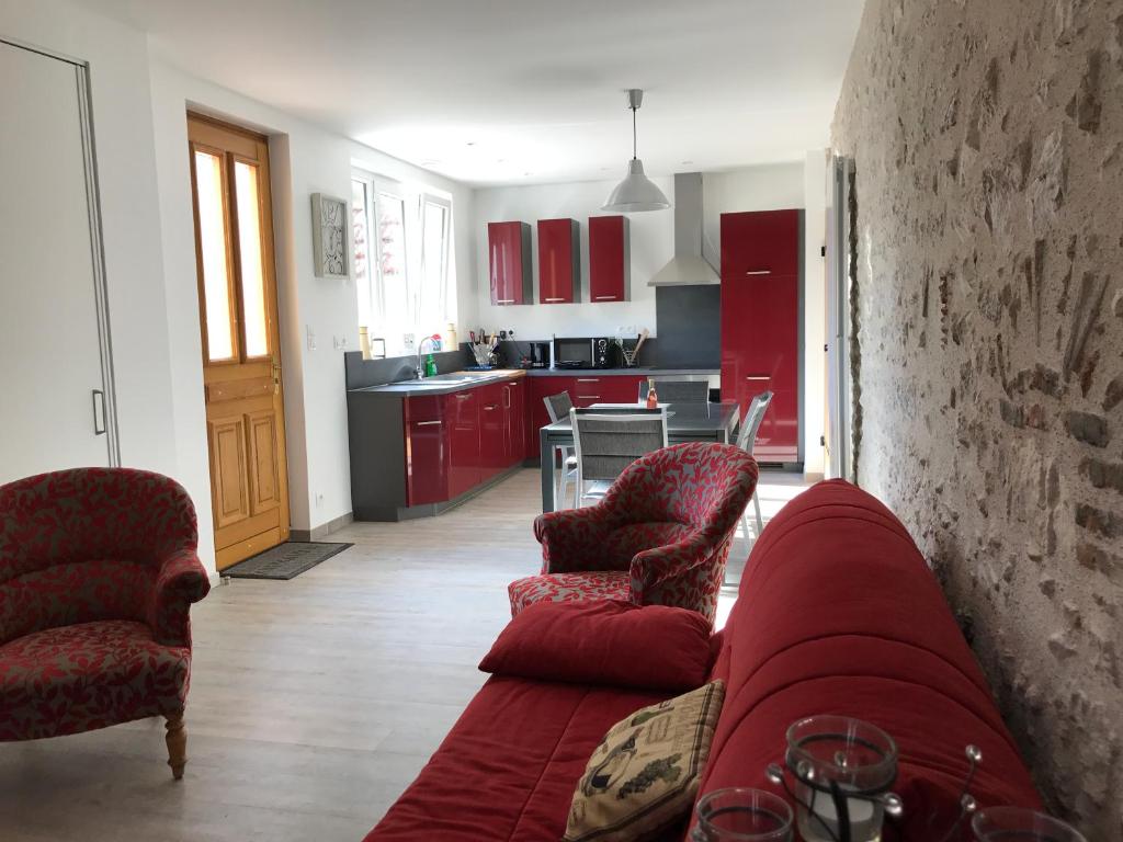 卢瓦尔河畔默恩Gîte du Parc des Mauves的客厅配有红色的沙发和两把椅子