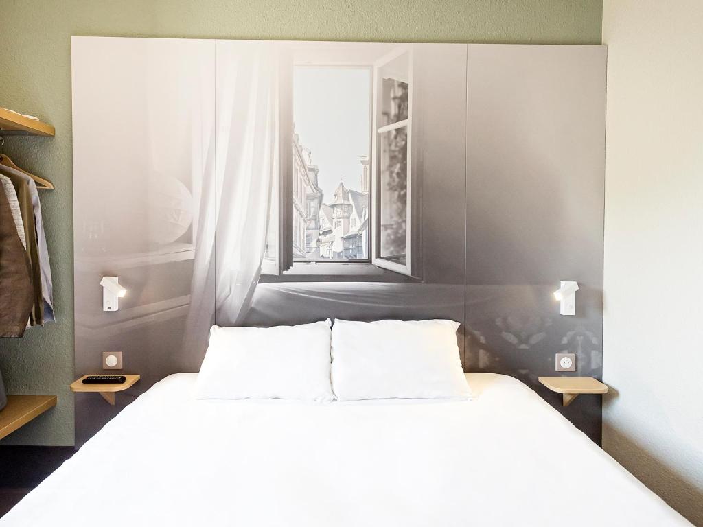 万泽内姆B&B HOTEL Colmar Vignobles Ouest的一间卧室设有一张大床和一个窗户。